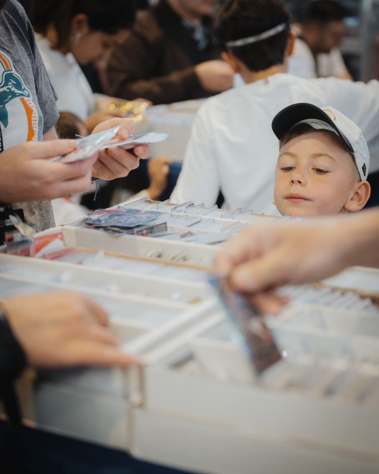 Young collector looking through a box of trading cards at CARDMADNESS