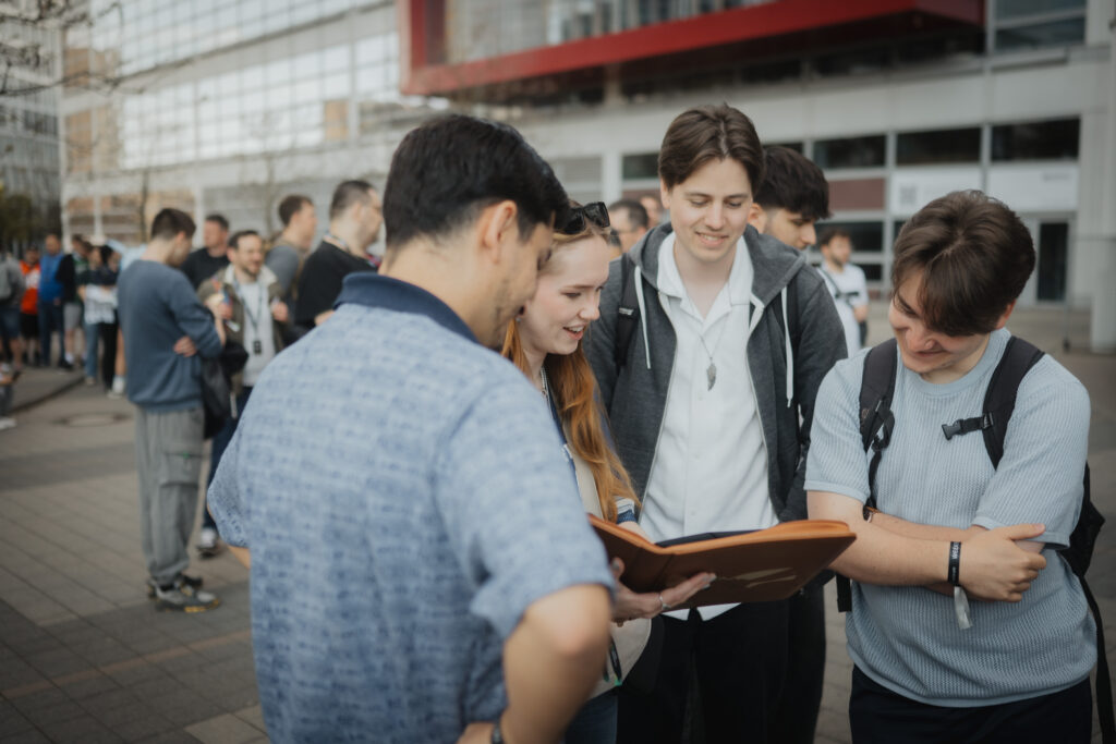 Four young visitors going through a card binder outside the CARDMADNESS hall