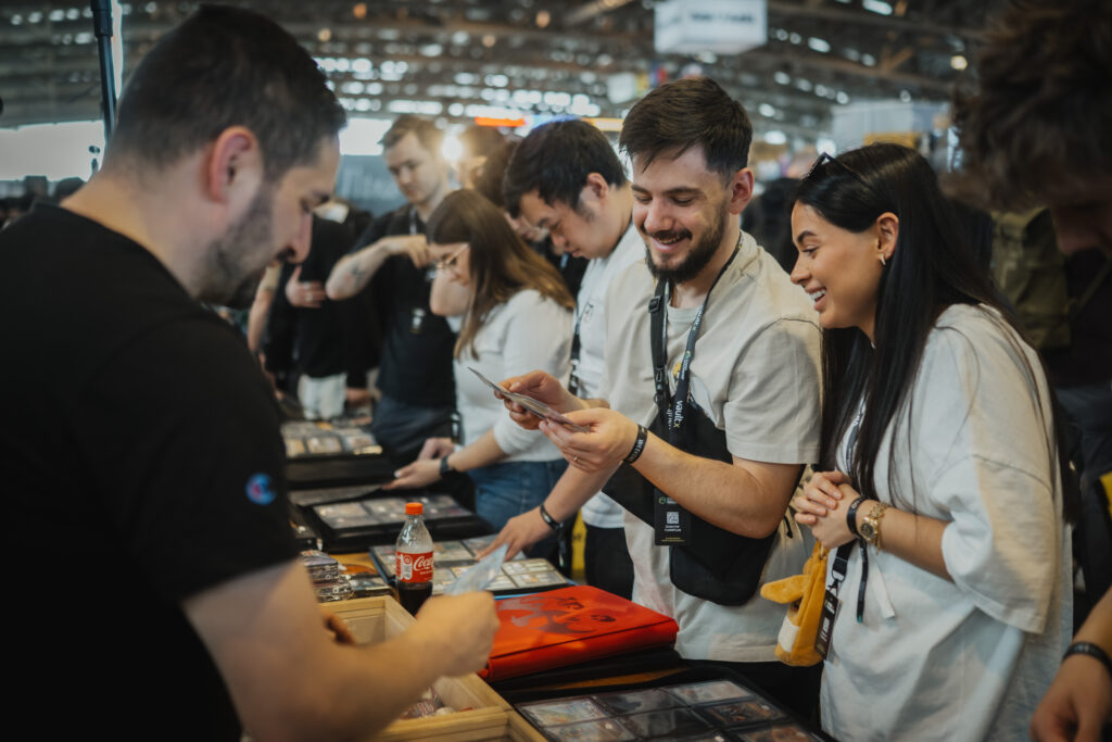 Group of collectors comparing trading cards at a booth during CARDMADNESS